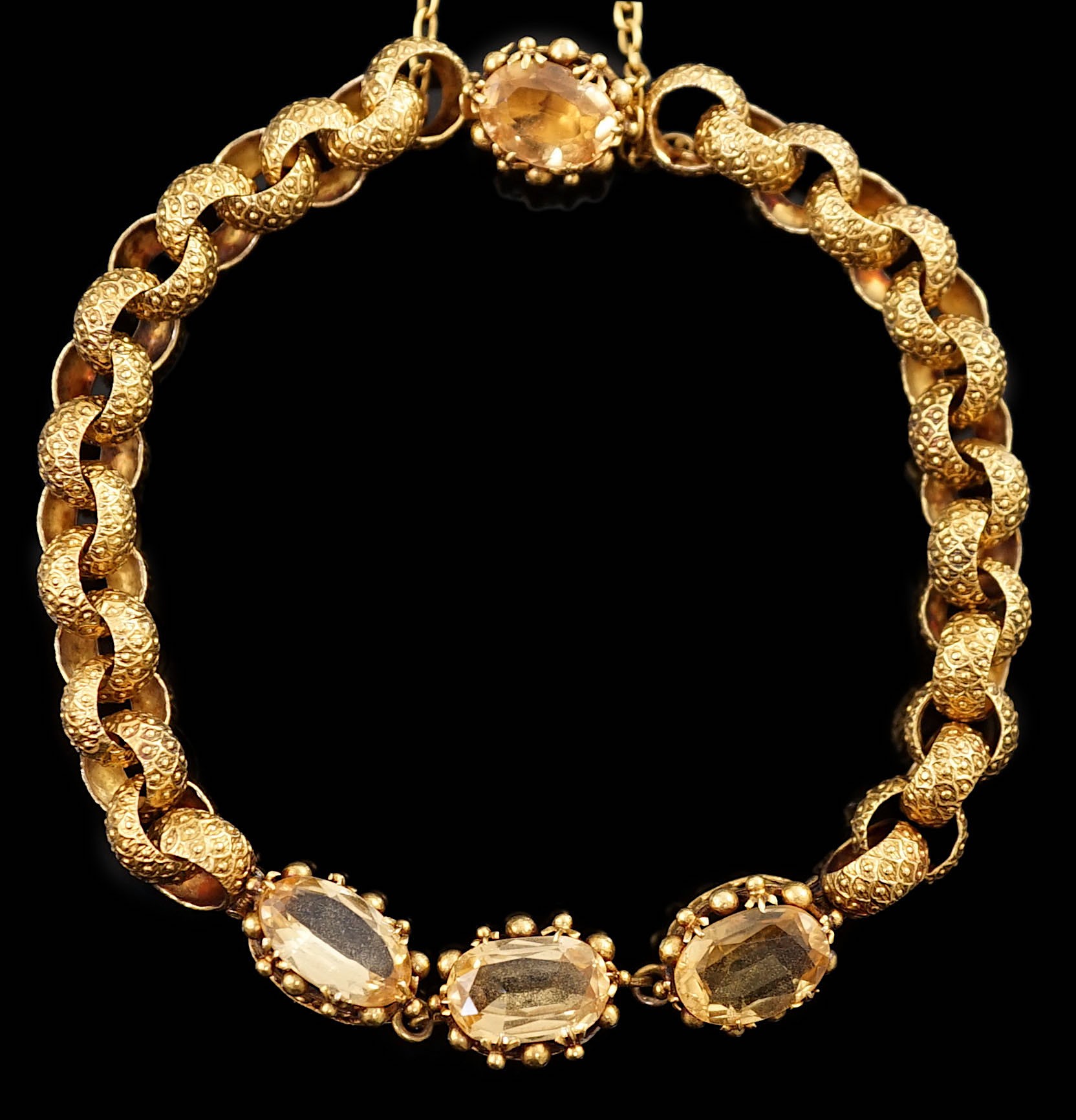 A 19th century cannetille work gold and four stone oval cut citrine set circular link bracelet